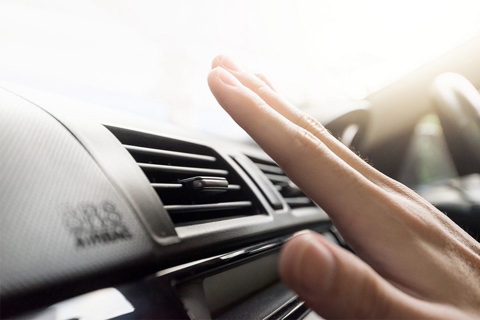 Mand tjekker om der kommer luft ud af udluftning i bilen