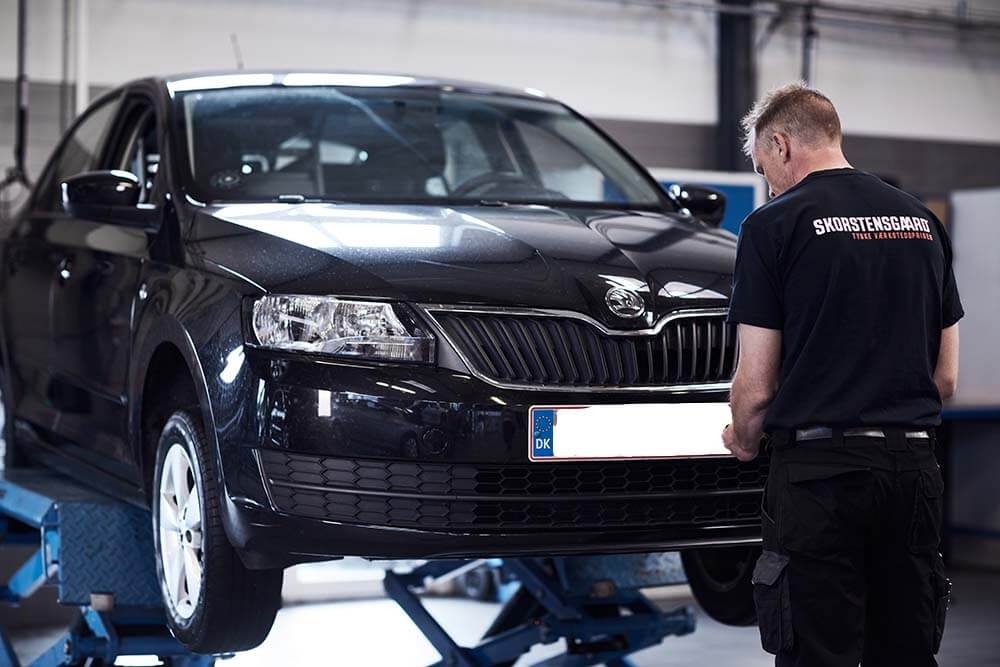 Skorstensgaard med Skoda bil på liften på værksted